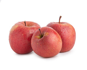 Three red fuji apples in water drops on a white isolated background