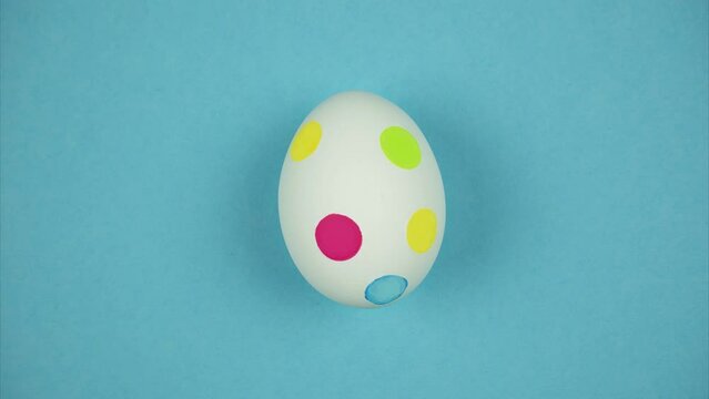 Round colored candies move near egg and paint it in the Easter egg. Stop motion animation
