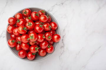plate with cherry tomatoes on white marble background
