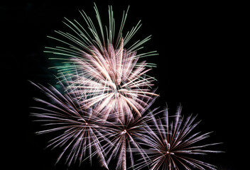 Festive fireworks. Bright rays of light against the black night sky.