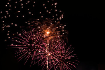 Festive fireworks. Bright rays of light against the black night sky.
