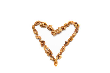A handful of walnuts in the shape of a heart. Isolated on white background. Nuts are available in two forms, shell or shelled, and can be whole, halved, or in smaller portions due to processing.