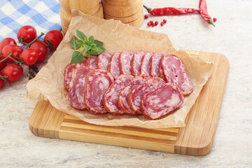 Sliced salami sausages over board