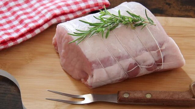 piece of raw pork meat with rosemary ready for baking, video