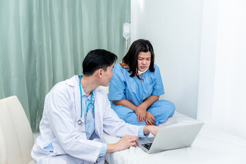 Asian woman patient looking at computer and listening  doctor Explaining treatment procedures And...