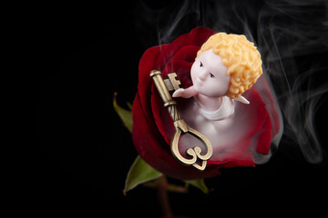 image of flower miniature angel figure key smoke dark background 