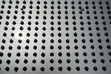 Silberne Metallfläche mit schwarzem Noppenmuster 