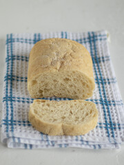Cutaway ciabatta on the waffle kitchen towel. Piece of italian bread. White background