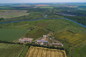 The countryside on a bright sunny day, fields and villages. Steppe plain area with a river. Bird's eye view. View from a drone.