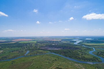 Fototapeta na wymiar The countryside on a bright sunny day, fields and villages. Steppe plain area with a river. Bird's eye view. View from a drone.
