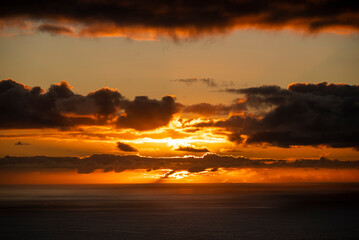 Picturesque seascape with a very beautiful sunset and illuminated clouds over the Atlantic Ocean at the west coast of Madeira, seen from Ponta do Pargo lighthouse
