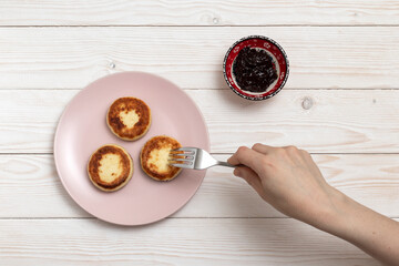 Fried curd fritters and fruit jam on a wooden table. Top view.