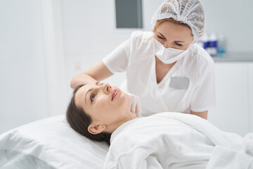Obraz na płótnie Canvas Woman receiving rejuvenating beauty injection in cosmetology clinic