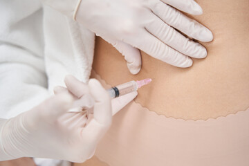 Woman receiving abdomen rejuvenating injection in beauty clinic