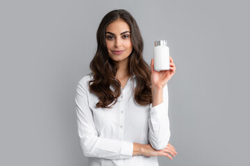 Woman with bottle pills. Pretty woman holding a bottle with dietary supplement, vitamins and...