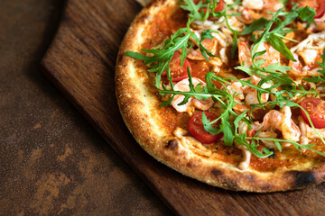 Mediterranean pizza with shrimps on a wood desk close up