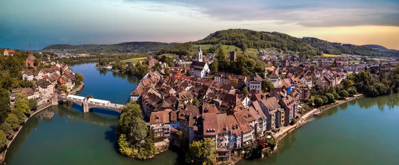 Poster Romantic beuatiful paces of Switzerland . Laufenburg town over Rhein river. popular tourist destination, border with Germany. Aerial panoramic view over sunset © Freesurf
