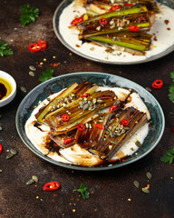 Sweet and sour braised leeks over whipped feta cheese, vegetarian vegan summer Asian style food concept