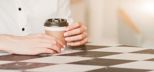  hands holding a paper cup with coffee