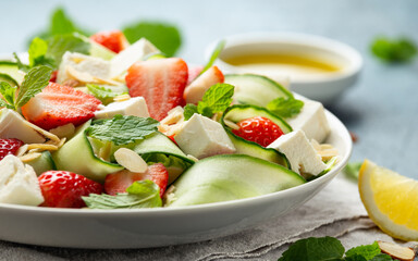 Summer Strawberry, cucumber salad with lettuce, feta cheese and almonds. Healthy Food.