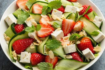 Summer Strawberry, cucumber salad with lettuce, feta cheese and almonds. Healthy Food.