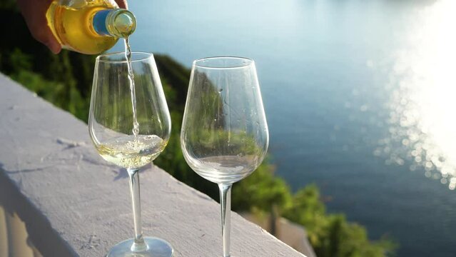 Two glasses of white wine with Corfu in background