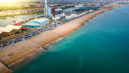 Beach by industrial estate in Brightonand Hove on a clear sunny day