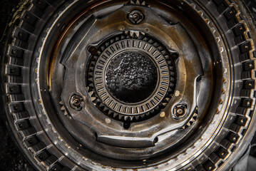 Gears, cogs and bearing of a dissasembled gearbox in a garage ready for repair