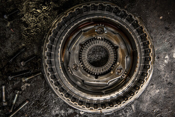 Gears, cogs and bearing of a dissasembled gearbox in a garage ready for repair