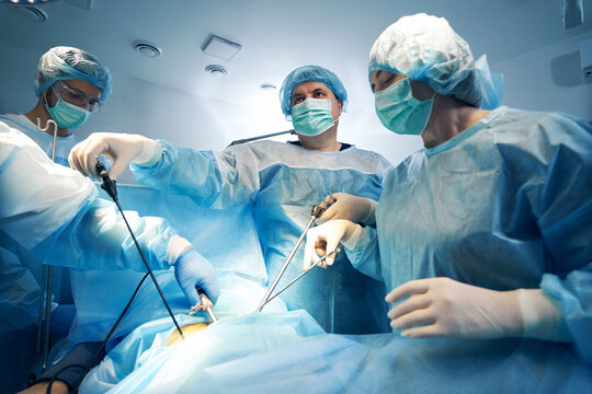Specialist in surgery using laparoscopic tools while operating on patient