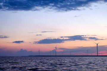 Fototapeta na wymiar Wind turbines near the lake. Sunset landscape.