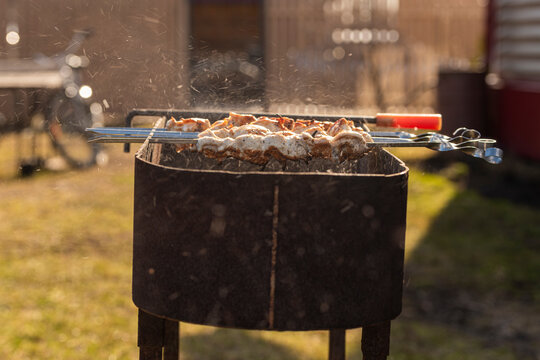 cooking chicken kebabs on a barbecue on a country plot, the concept of a weekend and a country holiday