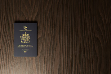 Saint Kitts and Nevis passport  on dark brown wooden plank, citizenship by investment