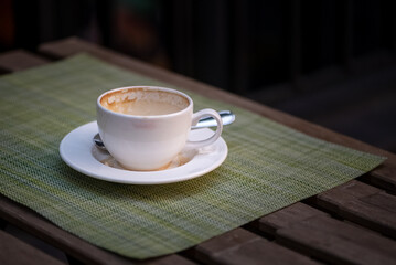 Empty coffee cup with milk foam stains on the edges on street cafe table