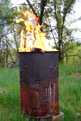 Flames spreading out from a fire 
 metal barrel 