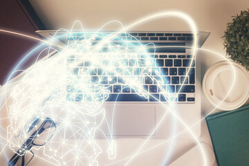 Business theme hologram drawings over computer on the desktop background. Top view. Multi exposure. Concept of international connections.