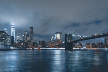 Obraz premium Brooklyn Bridge at Night with Water Reflection in New York City