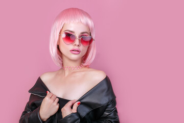 Stylish portrait of woman in sunglasses with bright colored pink hair and pink make-up in sunglasses