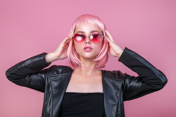 Stylish portrait of woman in sunglasses with bright colored pink hair and pink make-up in sunglasses
