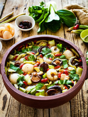 Yunnan hot pot - chinese soup with chicken meat on wooden table
