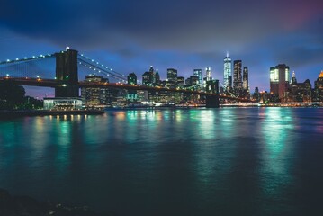 Fototapeta premium Brooklyn Bridge at Night with Water Reflection in New York City