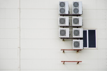 An example of installing a plurality of air conditioners on the outer wall of an office building. Air conditioners installed next to the window on the surface of the siding.