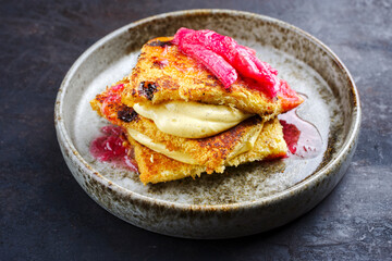 Traditional roasted Italian panettone tiramisu with vanilla custard curd and rhubarb served as close-up in a Nordic design bowl