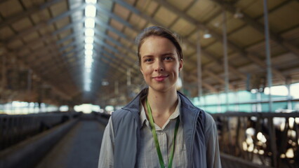 Smiling woman posing shed aisle alone portrait. Agricultural specialist at work.