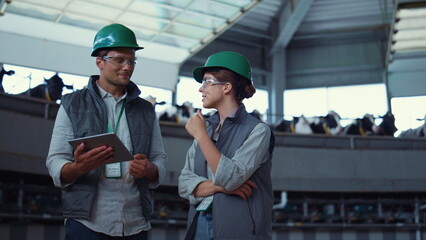 Farm specialists talking dairy manufacture. Supervisors holding pad computer.