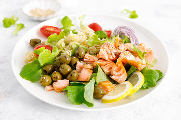 Grilled salmon salad with fresh lettuce, tomatoes, green olives, red onion and pasta. Healthy food, diet