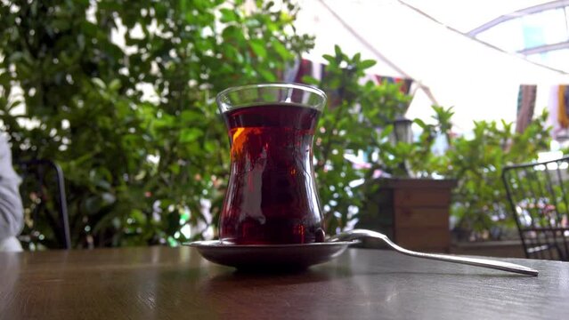 Close up view of young teen girl drinking tea in a cafe. Slow motion.It fills Turkish tea into a glass special to the Turks.