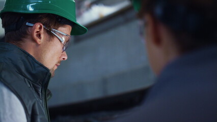 Engineer working at livestock facility closeup. Focused workers wearing uniform.