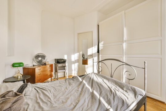 Bedroom interior with metal frame bed and commode