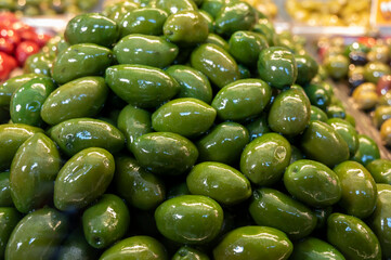 Green fresh olives close up on market, food background